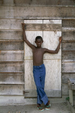 Jongen met blauwe spijkerbroek voor schuur